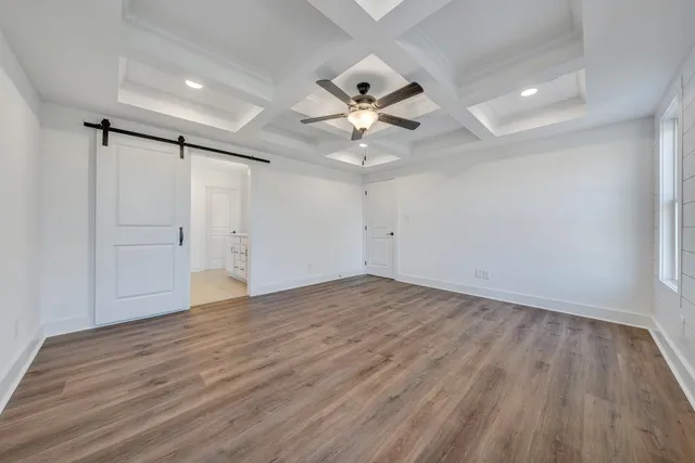 an empty room with wooden floor and ceiling fan