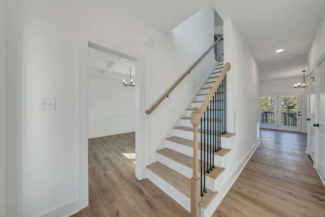 a view of a hallway with wooden floor and staircase