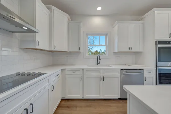 a kitchen with white cabinets and appliances