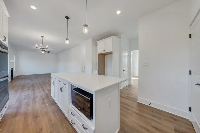 a kitchen with a stove a sink and a chandelier