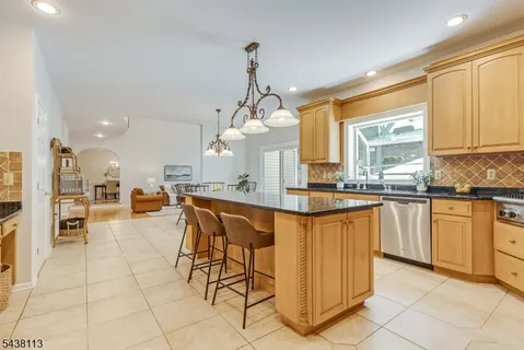 a kitchen with stainless steel appliances granite countertop a stove a sink a oven and a refrigerator