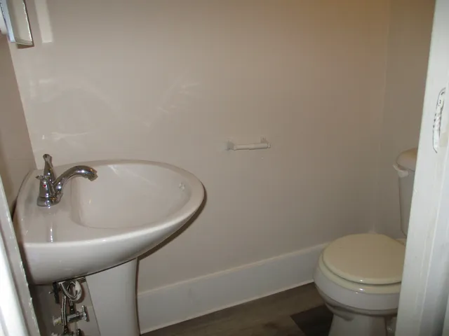 a white toilet sitting next to a shower