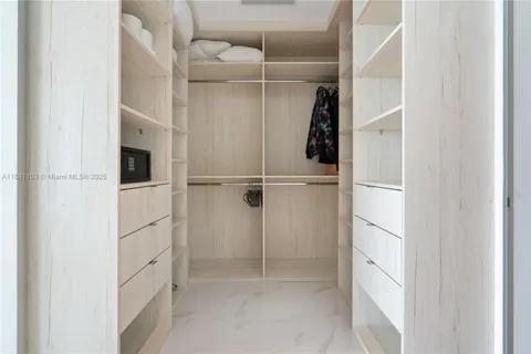 a view of walk in closet with racks on the wall
