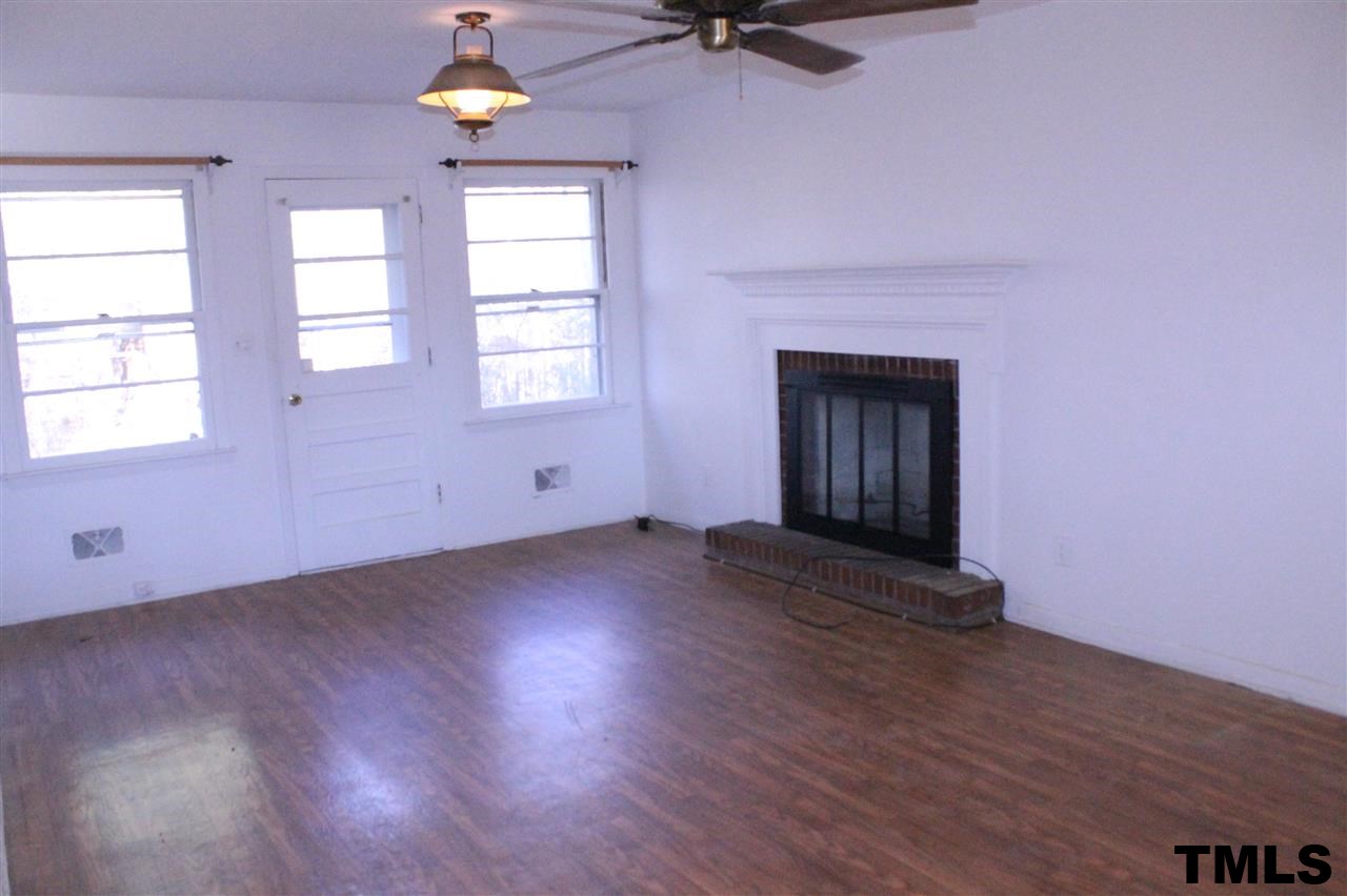 3900 Pearl Road Raleigh, NC 27610 - Photo 8 of 21 an empty room with wooden floor chandelier fan and windows