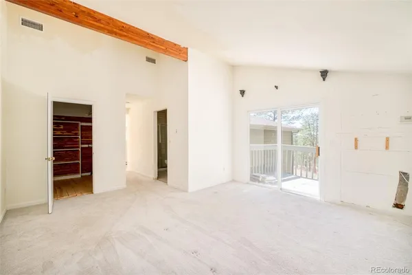 a view of empty room with wooden floor and windows