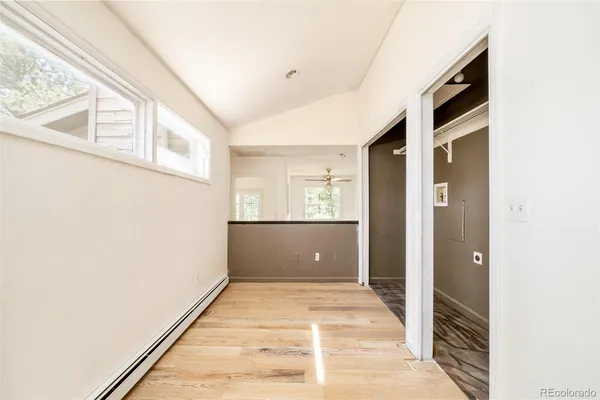 a view of a hallway with wooden floor and staircase
