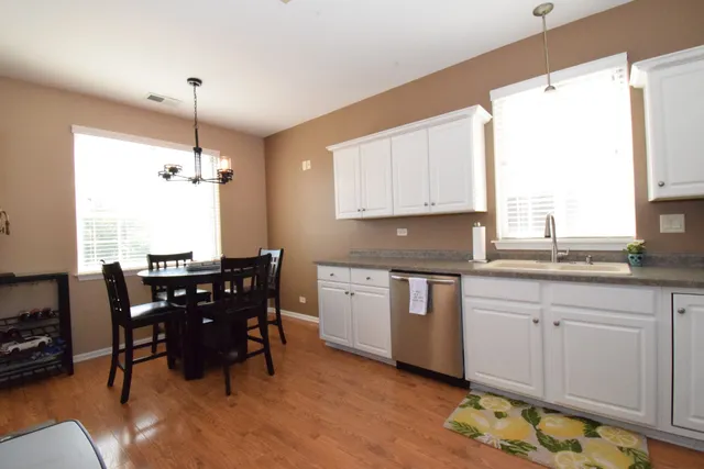 a kitchen with granite countertop cabinets stainless steel appliances a dining table and chairs