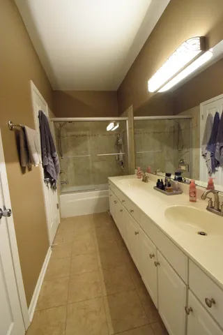 a bathroom with a double vanity sink a mirror and a shower