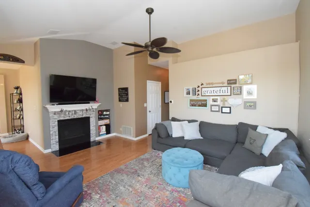 a living room with furniture a fireplace and a flat screen tv