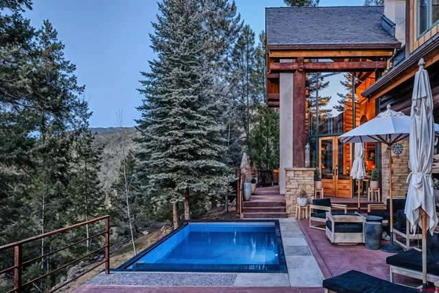 a view of a brick house with large trees and a yard