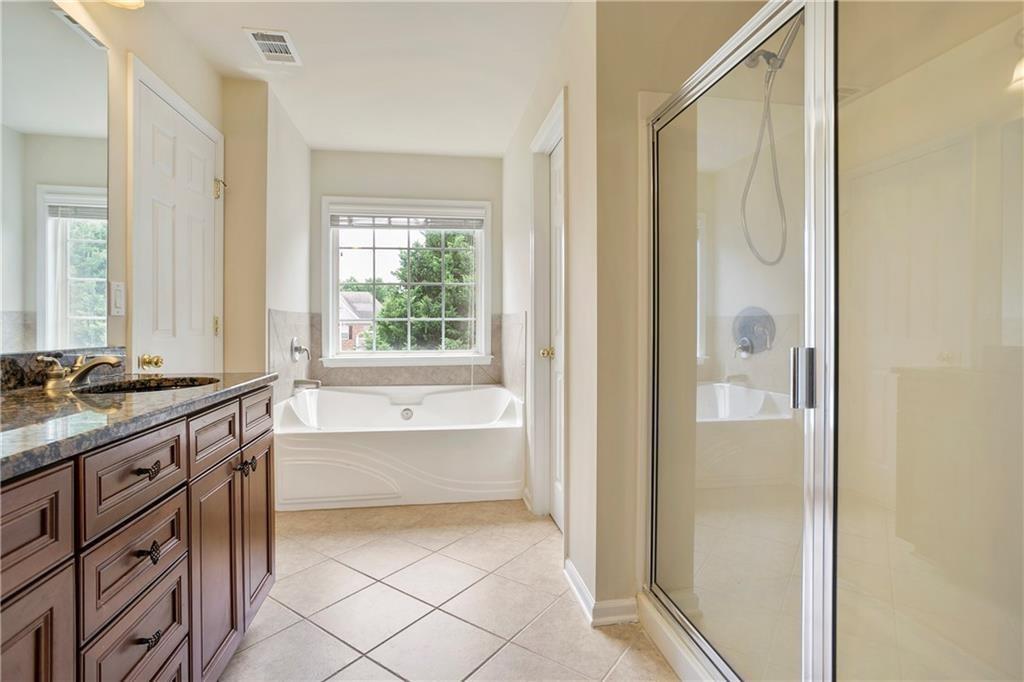 6108 Joybrook Road Johns Creek, GA 30097 - Photo 14 of 22 a bathroom with a granite countertop sink a mirror and a bathtub