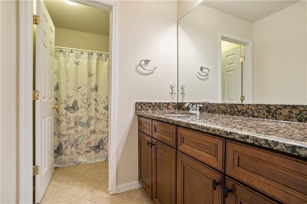 6108 Joybrook Road Johns Creek, GA 30097 - Photo 18 of 22 a bathroom with a granite countertop sink and a mirror