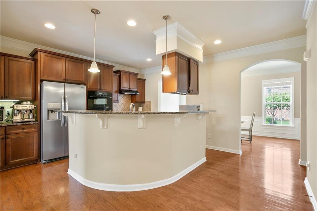 6108 Joybrook Road Johns Creek, GA 30097 - Photo 4 of 22 a view of a kitchen with kitchen island a counter top space appliances and a ceiling fan