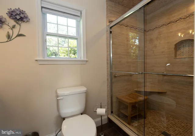 a bathroom with a toilet and a shower