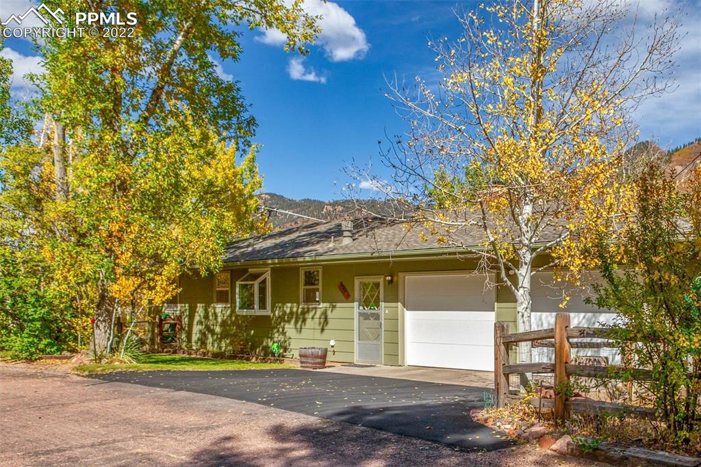 9610 Mohawk Trail Cascade, CO 80809 - Photo 1 of 38 a front view of a house with a garden