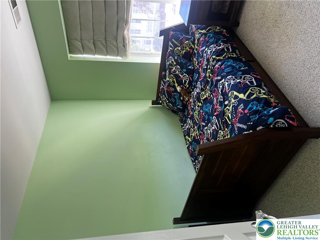8549 Gateway Road Breinigsville, PA 18031 - Photo 22 of 26 A window-lit bedroom features durable carpeting and a bed frame, offering comfortable living.