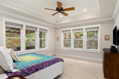 a bedroom with furniture and a large window