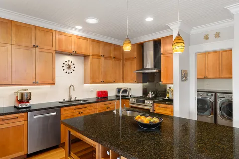 a kitchen with stainless steel appliances granite countertop a sink a stove and a refrigerator