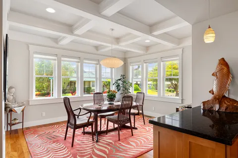 a dining room with furniture a chandelier and wooden floor