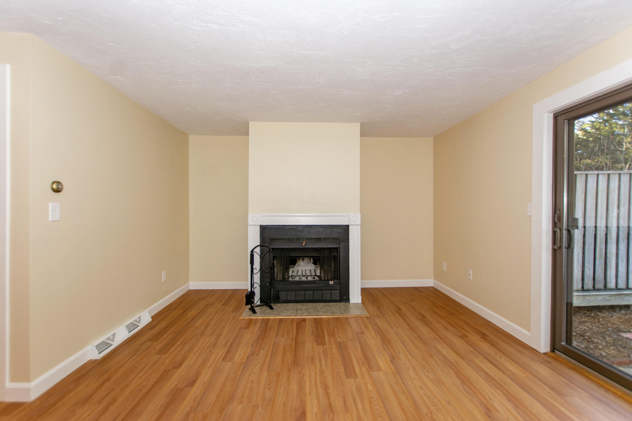 52 Shellback Way, Unit H Mashpee, MA 02649 - Photo 11 of 20 a view of an empty room with wooden floor fireplace and a window