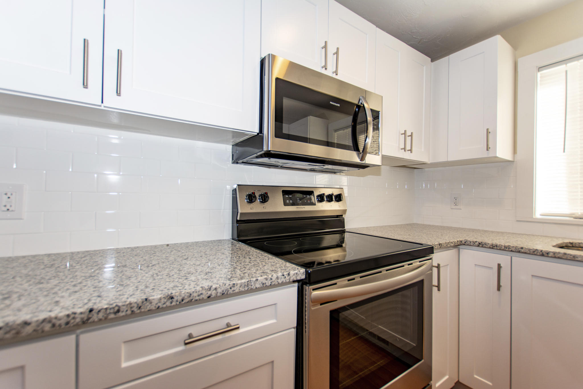 52 Shellback Way, Unit H Mashpee, MA 02649 - Photo 5 of 20 a kitchen with granite countertop white cabinets appliances and a window