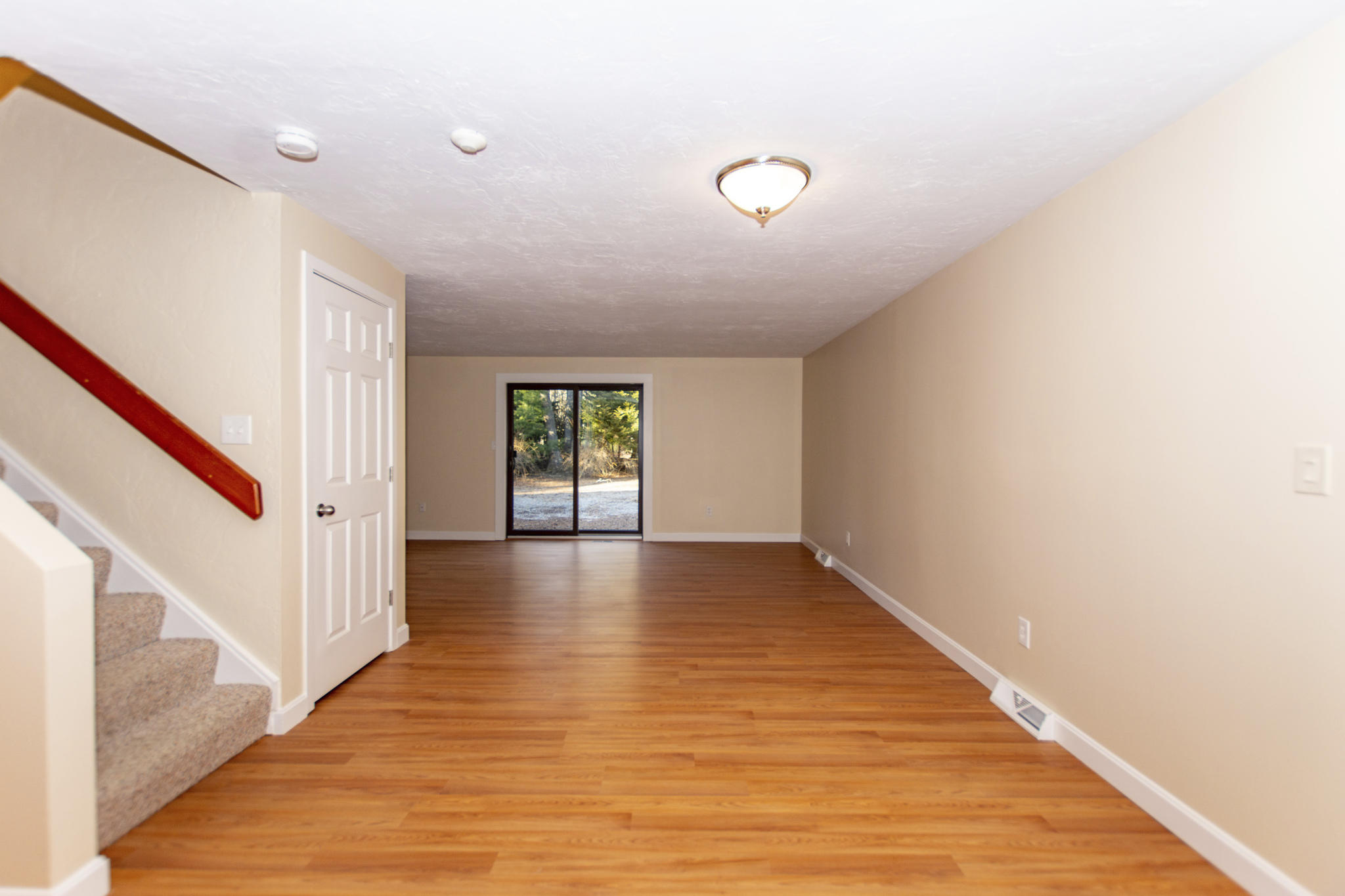 52 Shellback Way, Unit H Mashpee, MA 02649 - Photo 8 of 20 a view of an empty room with wooden floor and stairs