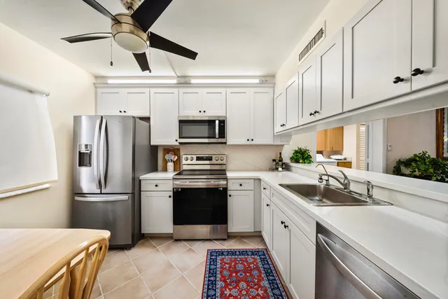 a kitchen with cabinets stainless steel appliances and a counter space