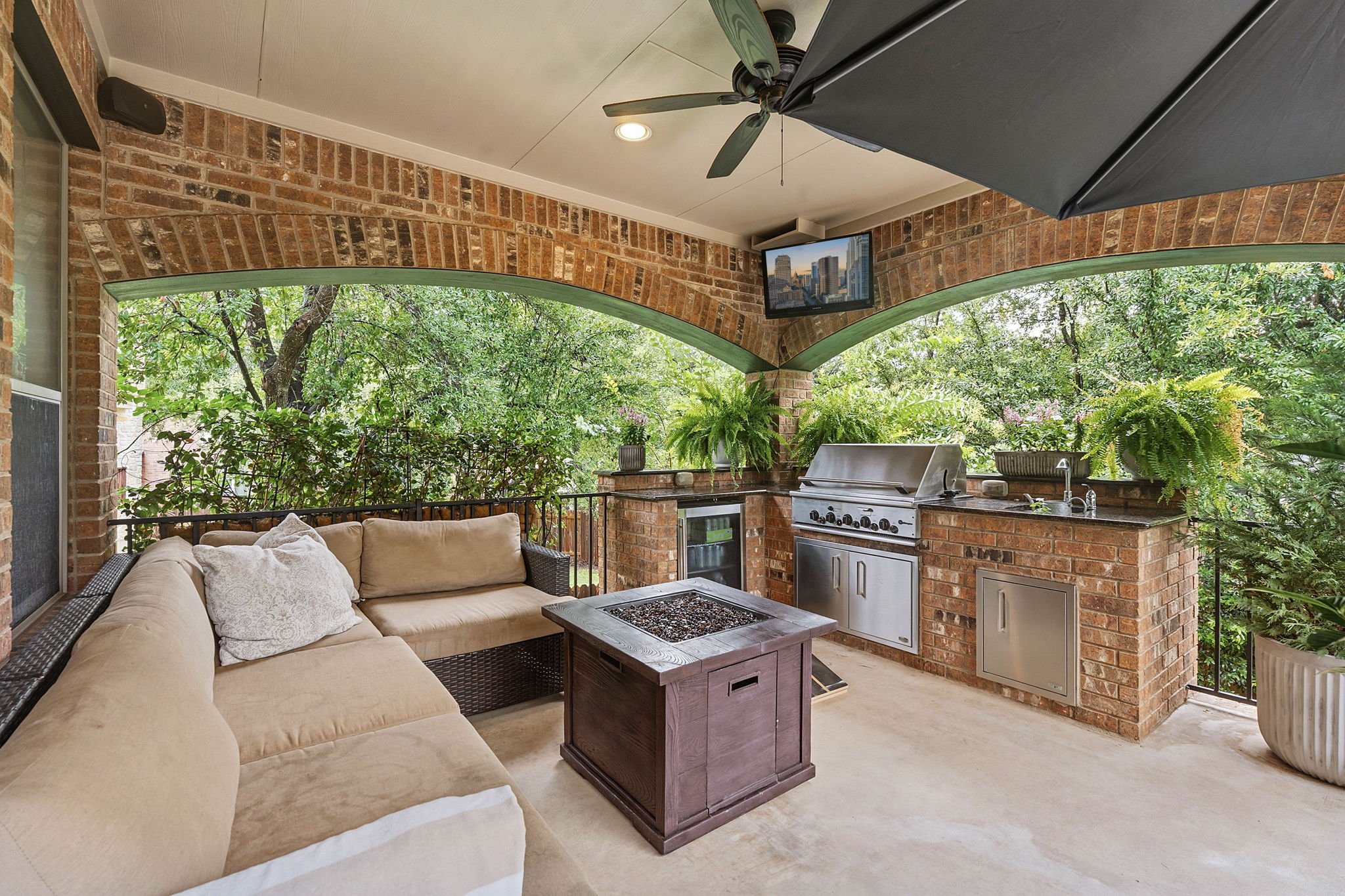 12321 Edenvale Path Austin, TX 78732 - Photo 30 of 36 An inviting covered outdoor living area awaits with a built-in kitchen, ideal for year-round enjoyment.