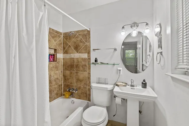 a bathroom with a sink toilet and shower