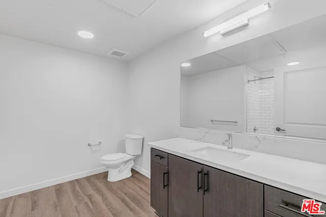 a bathroom with a sink toilet and a large mirror