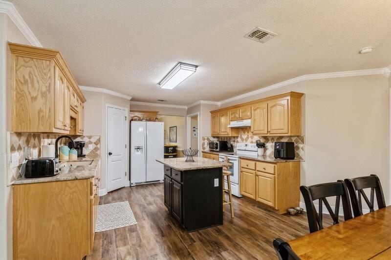 422 Swift Fox Run Crestview, FL 32536 - Photo 12 of 35 a kitchen with sink cabinets and wooden floor