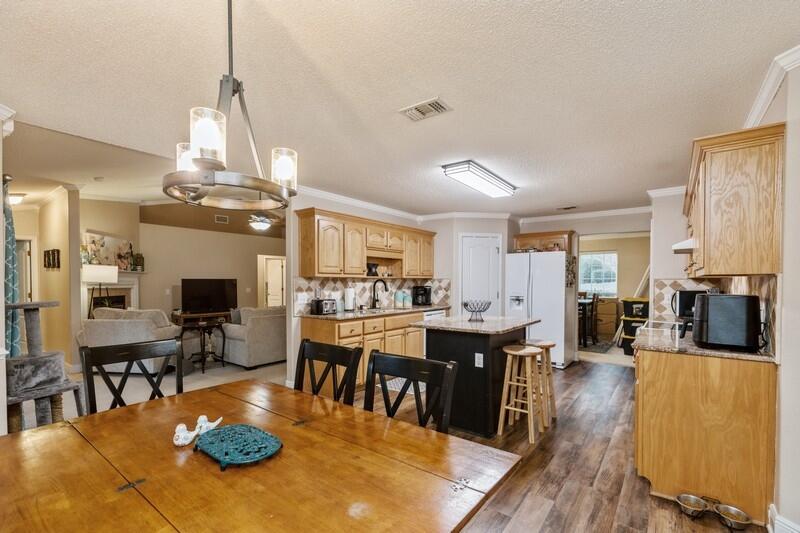 422 Swift Fox Run Crestview, FL 32536 - Photo 14 of 35 a view of a dining room and livingroom with furniture wooden floor a chandelier