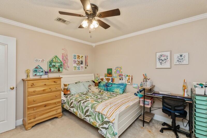 422 Swift Fox Run Crestview, FL 32536 - Photo 16 of 35 a bedroom with a bed and a chandelier