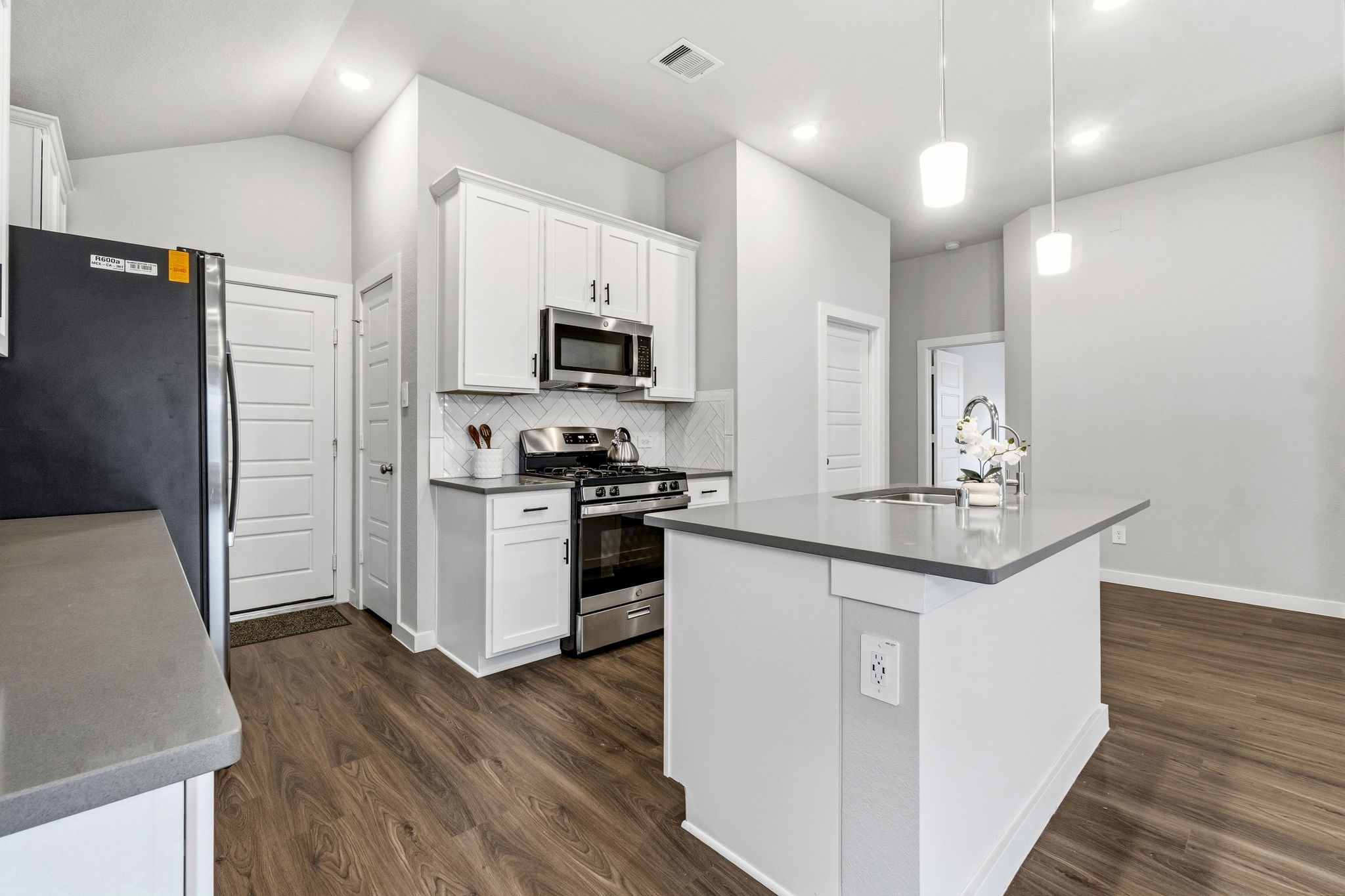 22235 Cardinal Crest Lane New Caney, TX 77357 - Photo 6 of 41 Beautiful kitchen featuring upgraded cabinetry, ample counter space, and an open design that flows seamlessly into the dining and family room
