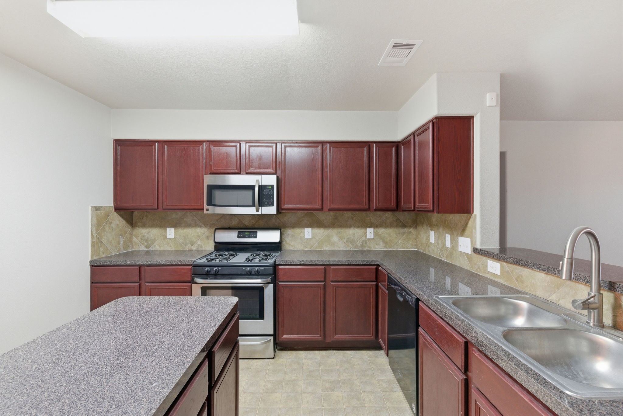 4910 Conifer Ridge Way Humble, TX 77346 - Photo 18 of 48 a kitchen with kitchen island granite countertop wooden cabinets a stove a sink and a oven with wooden floor