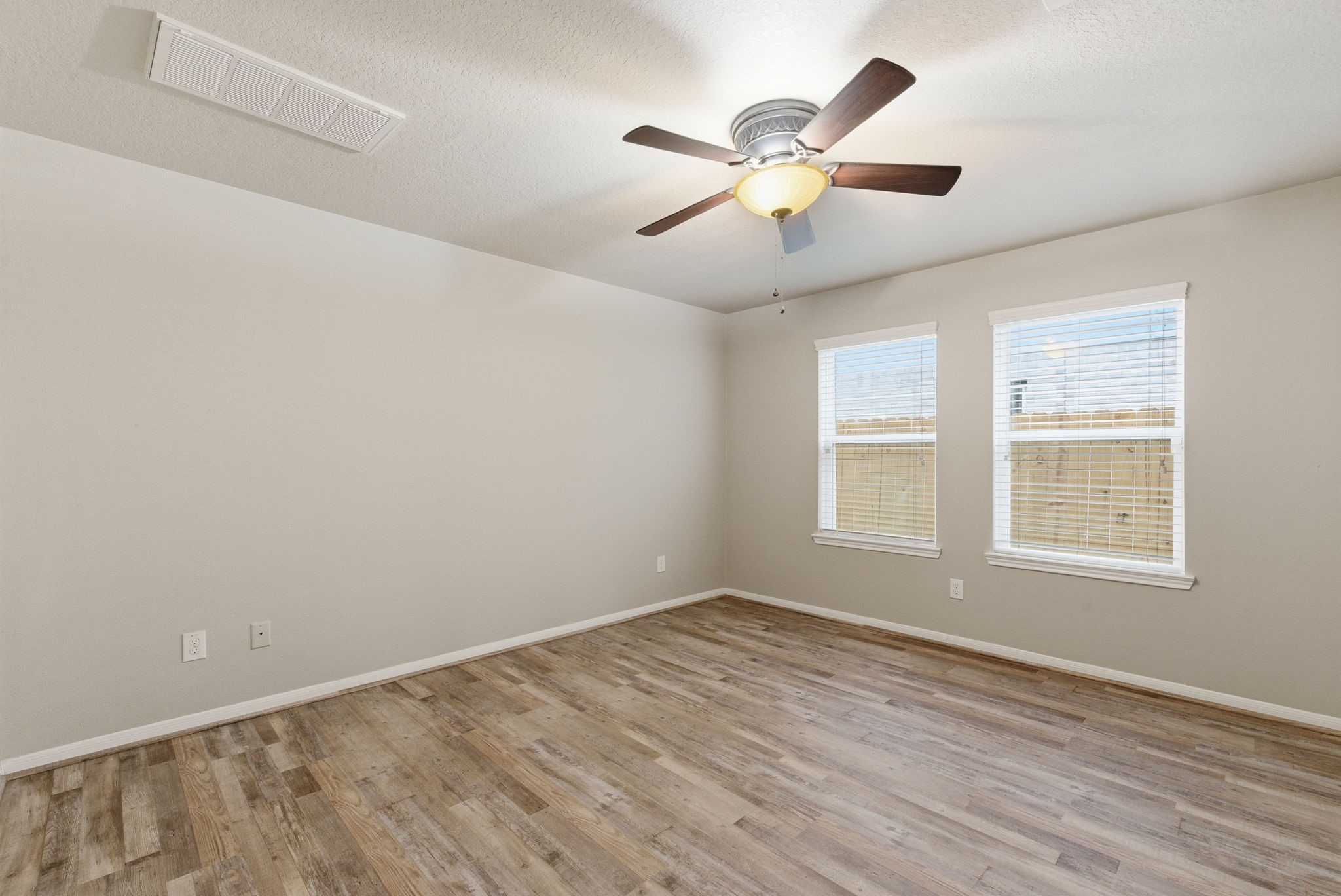 4910 Conifer Ridge Way Humble, TX 77346 - Photo 21 of 48 an empty room with wooden floor fan and windows