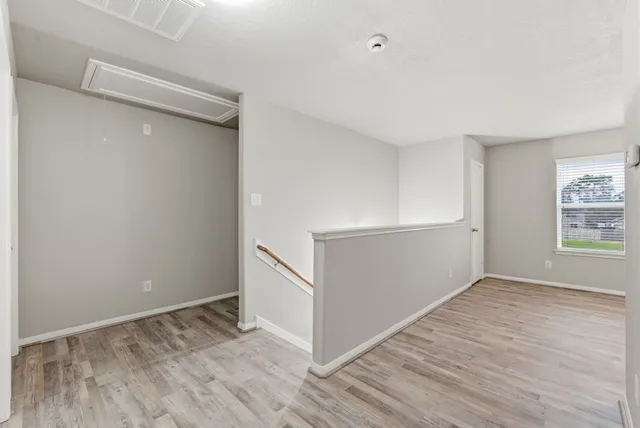 a view of an empty room with wooden floor