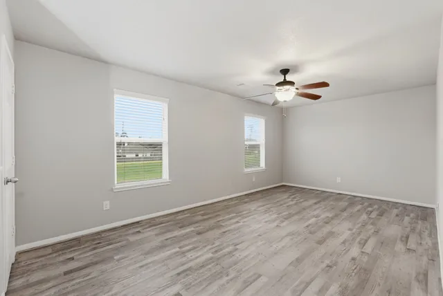 a view of an empty room with a chandelier fan