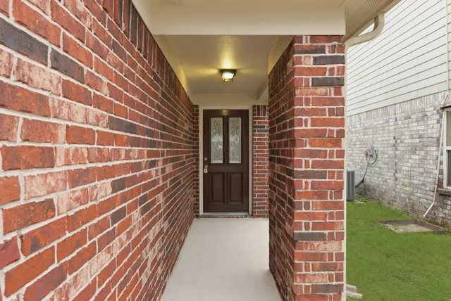 a view of an empty room with wooden floor fireplace and a window