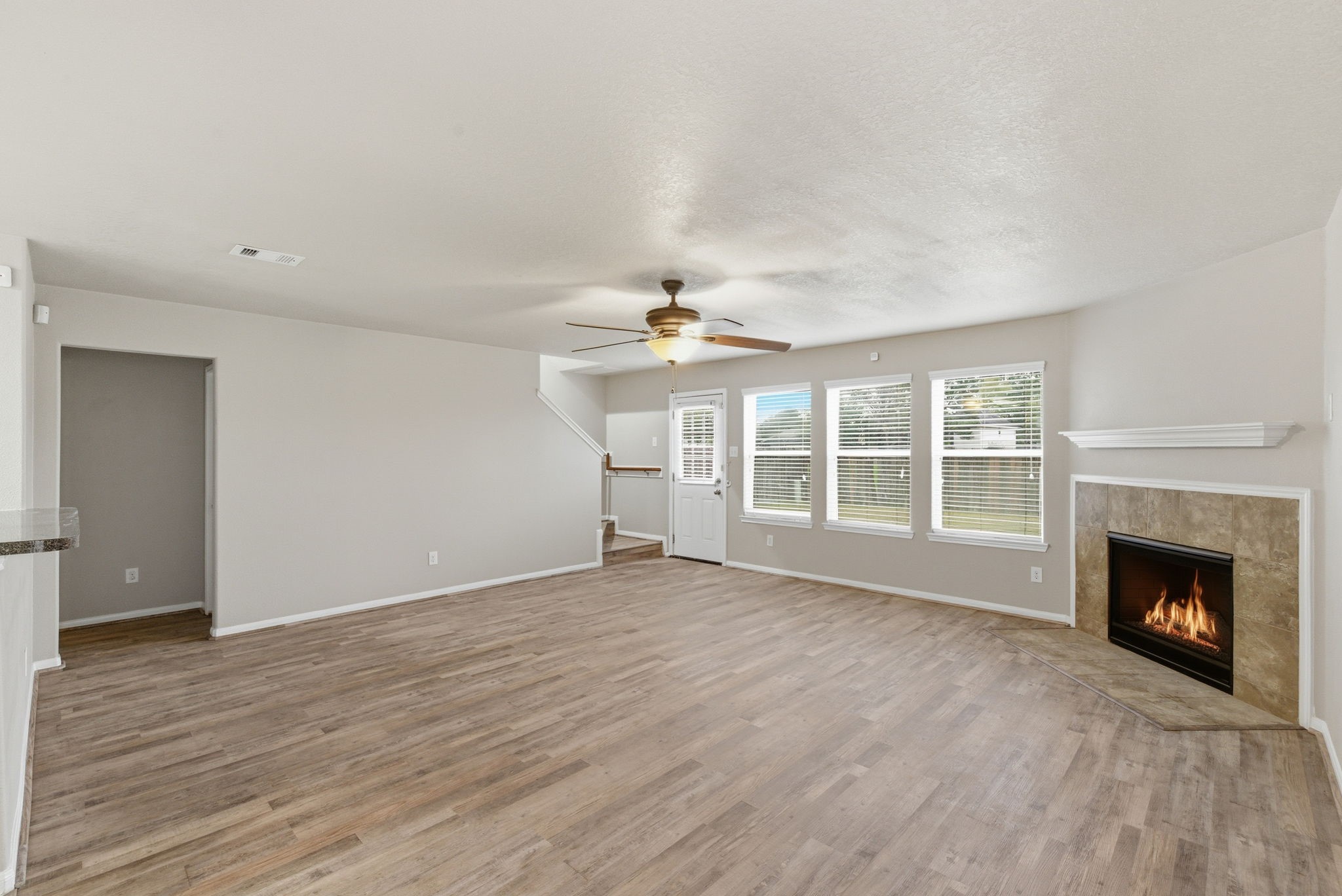 4910 Conifer Ridge Way Humble, TX 77346 - Photo 9 of 48 a view of an empty room with wooden floor fireplace and a window