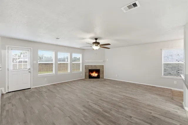 a view of an empty room with window and fireplace