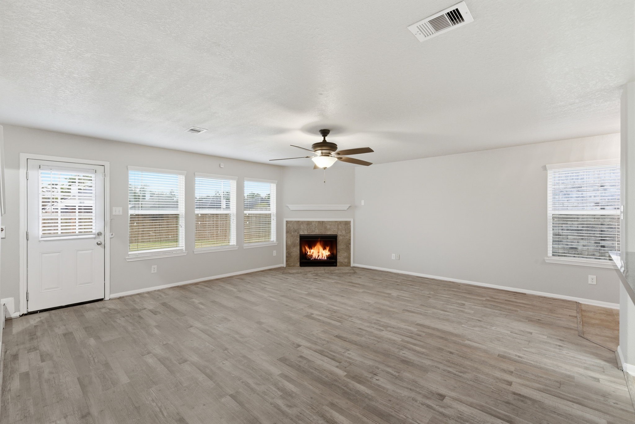 4910 Conifer Ridge Way Humble, TX 77346 - Photo 10 of 48 an empty room with windows and fireplace