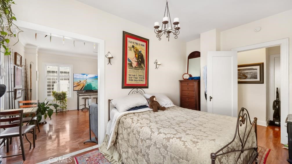 140 Linden Avenue, Unit 962 Long Beach, CA 90802 - Photo 14 of 21 a bedroom with a bed and chandelier
