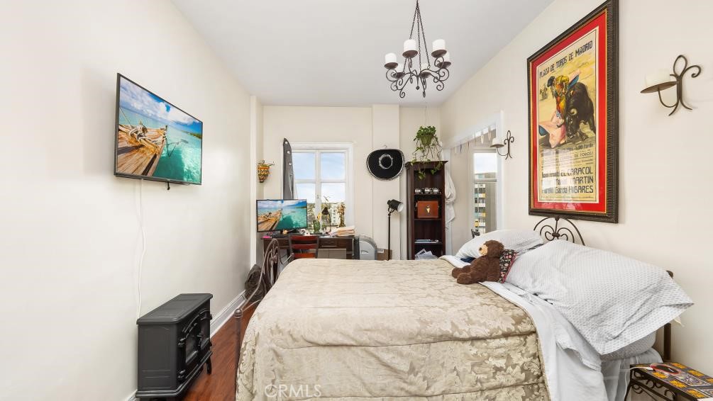 140 Linden Avenue, Unit 962 Long Beach, CA 90802 - Photo 16 of 21 a bedroom with a bed and a chandelier