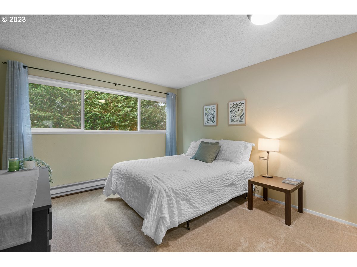 4308 Southwest Dickinson Street, Unit 15 Portland, OR 97219 - Photo 18 of 35 a bedroom with a bed window and a night stand