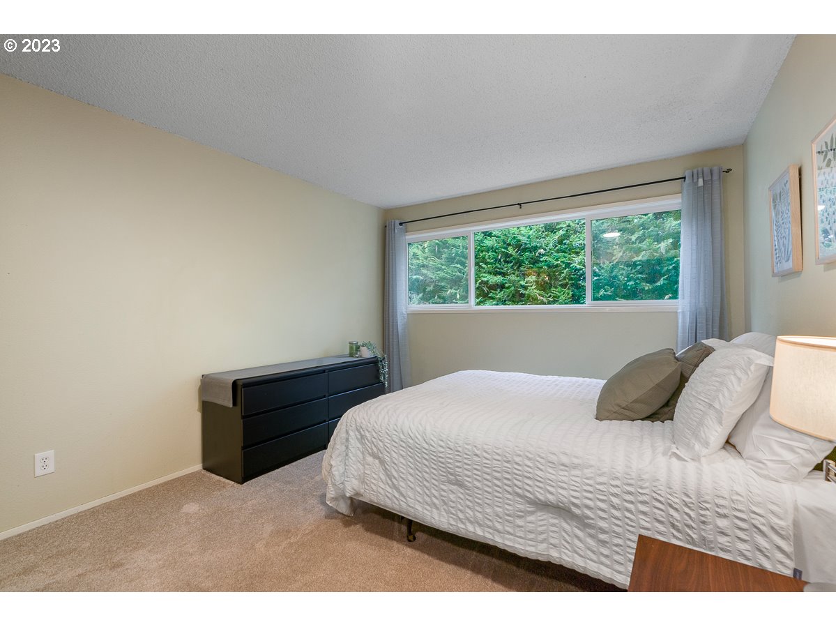 4308 Southwest Dickinson Street, Unit 15 Portland, OR 97219 - Photo 19 of 35 a bedroom with a bed window and a night stand