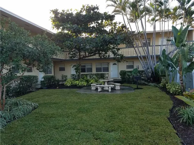 a view of backyard of house with green space and outdoor seating
