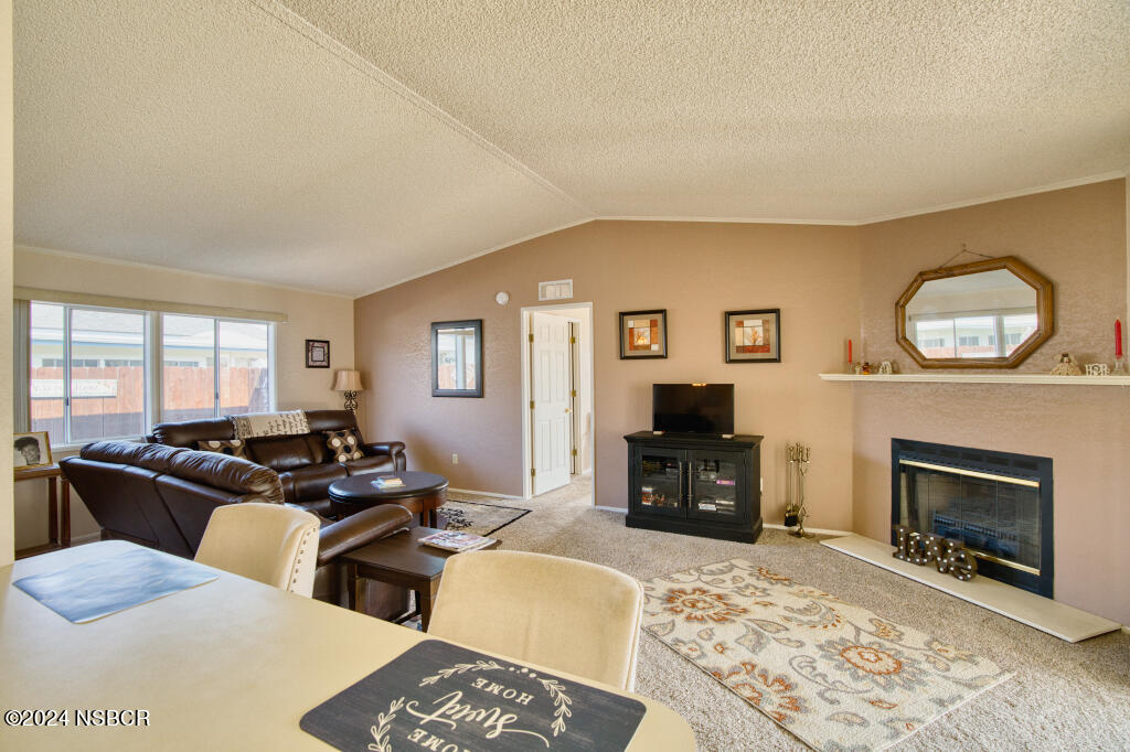 919 Vista Del Rio Santa Maria, CA 93458 - Photo 2 of 29 a living room with furniture a fireplace a flat screen tv and a large window