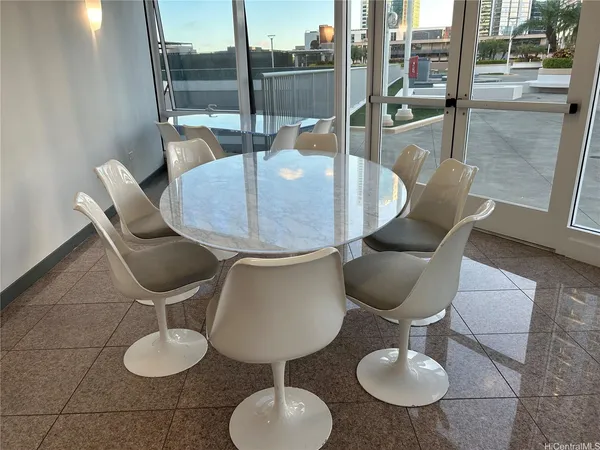 a dining room with furniture and a floor to ceiling window