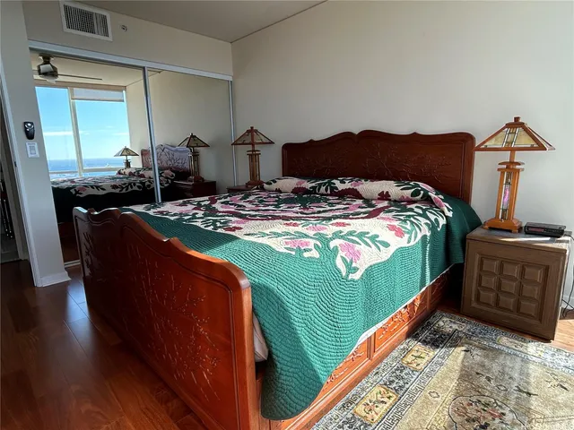 a bedroom with bed and wooden floor